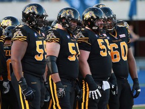 Brian Simmons (59), Jeremiah Masoli (8), Tim O'Neill (55) and Dominic Alford (60) of the Hamilton Tiger-Cats line up against the Toronto Argonauts during a 2014 game in Toronto. The Eskimos acquired Simmons in a trade on Thursday.