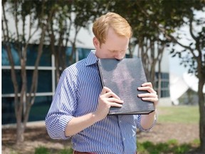 WDBJ7 news anchor Chris Hurst pauses as he is overcome with emotion while holding a photo album that was created by fellow reporter and girlfriend Alison Parker, in Roanoke, Va., Wednesday, Aug. 26, 2015. The shooting of a television reporter and a cameraman unfolded on live TV before an audience of tens of thousands on the smaller market central Virginia television station.