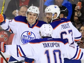 Edmonton Oilers centre Conner McDavid, left, celebrates scoring with linemates Nail Yakupov and Benoit Pouliot during the second period of NHL action at the Scotiabank Saddledome Saturday October 17, 2015, in Calgary.