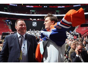Anton Lander of the Edmonton Oilers puts on a team jersey  handed to him from Stu MacGregor after being drafted in the second round of the 2009 NHL Entry Draft at the Bell Centre on June 27, 2009 in Montreal.