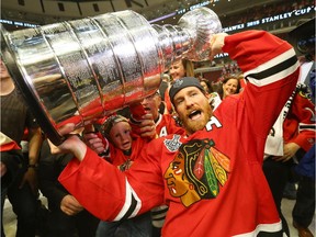 Duncan Keith of the Chicago Blackhawks celebrates by hoisting the Stanley Cup after defeating the Tampa Bay Lightning  to win the 2015 Stanley Cup on June 15, 2015 in Chicago, Illinois.