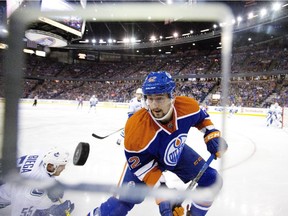 Vancouver Canucks' Alex Biega (55) falls as Edmonton Oilers' Anton Slepyshev (42) goes for the loose puck during second period NHL pre-season action in Edmonton, Alta., on Thursday October 1, 2015.