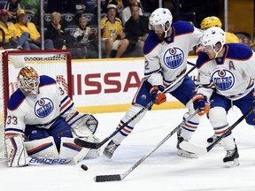 Edmonton Oilers goalie Cam Talbot (33) blocks a shot against the Nashville Predators as Oilers' Eric Gryba, center, and Andrew Ference, right, clear the puck in the second period of an NHL hockey game Saturday, Oct. 10, 2015, in Nashville, Tenn.