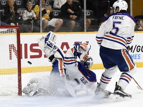 Nashville Predators right wing Craig Smith (not shown) scores a goal against Edmonton Oilers goalie Cam Talbot (33) as defenseman Mark Fayne (5) watches in the second period of an NHL hockey game Saturday, Oct. 10, 2015, in Nashville, Tenn.