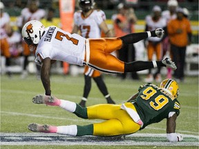 B.C. Lions' Lavelle Hawkins (7) leaps over Edmonton Eskimos' Willie Jefferson (99) during CFL action at Edmonton's Commonwealth Stadium on Oct. 17, 2015. The Eskimos won 26-23 in double overtime.