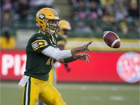 Edmonton Eskimos quarterback Mike Reilly (13) shovels the ball to a teammate during first half action against the BC Lions at Commonwealth Stadium on Oct. 17, 2015, in Edmonton.
