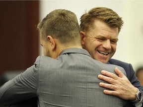 Wildrose Leader Brian Jean (right) embraces Wildrose MLA Derek Fildebrandt during a swearing-in ceremony in the house of the Alberta Legislature June 1, 2015.