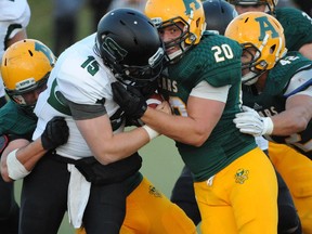 Linebacker Connor Ralph of the University of Alberta Golden Bears, looks to the sidelines in a 2014 game for the yardage markers while pushing Jeremy Long of the University of Saskatchewan Huskies back on a third and short yardage at Foote Field. Ralph will play his final regular season game as a Golden Bear on Saturday.