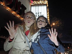 Edmonton Journal reporters Otiena Ellwand (left) and Paige Parsons (right) outside the Deadmonton Haunted House at the former Paramount Theatre in downtown Edmonton. Some believe that the building is actually haunted.