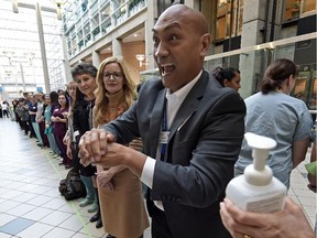 Runell Viray uses hand sanitizer during an attempt to set a world record for most staff members cleaing their hands consecutively at one time at the Royal Alexandra Hospital in Edmonton on Wednesday, Oct. 15, 2015.