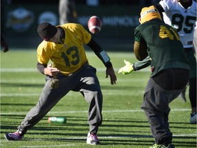 Edmonton Eskimos quarterback Mike Reilly and defensive end Odell Willis were playing around with a football during a practice at Commonwealth Stadium on Friday, Oct. 16, 2015.