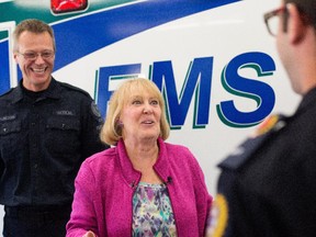 Sharon Smith, 64, is reunited with the ambulance crew who saved her life in Edmonton October 6, 2015. Todd Dundon, left, and Jason McNeil, right, responded to the call when she had a heart attack at a local casino while Dr. Ben Tyrrell, not pictured, treated her at the hospital.