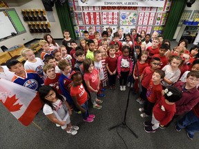 Rob Hanson, executive director of Hometown Music, directs and records children from Lago Lindo school singing O Canada in Edmonton on Wednesday .