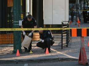 Police investigate the scene of an early morning shooting, which sent three people to hospital, on Friday, Oct. 9, 2015.