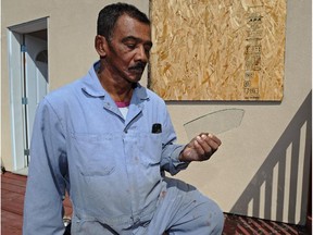 Chandar Singh looks at a piece of glass from his shattered bedroom window after he fought off an attacker in 2013.