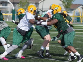 Offensive lineman D'Anthony Batiste, left, battles defensive lineman Marcus Howard during a one-on-one drill in the Edmonton Eskimos training camp at Fuhr Sports Park in Spruce Grove on June 3, 2015.