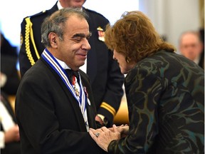 Researcher Jacob Masliyah receives a medal from Lt.-Gov. Lois Mitchell after being inducted into the Alberta Order of Excellence during a ceremony at Government House in Edmonton, October 14, 2015.