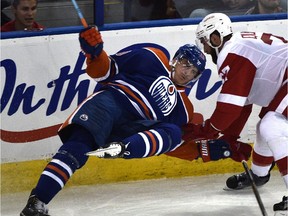 Edmonton Oilers' Nail Yakupov gets upended by Detroit Red Wings' Kyle Quincey during NHL action at Rexall Place on, Oct. 22, 2015.