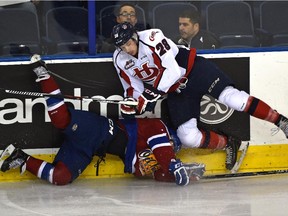 Edmonton Oil Kings' Luke Bertolucci (11) gets taken down by Lethbridge Hurricanes' Brady Reagan (28) during WHL action at Rexall Place in Edmonton, October 24, 2015.