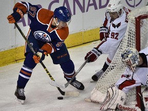 Edmonton Oilers' Connor McDavid (97) fights  Washington Capitals' Evgeny Kuznetsov for the puck during NHL action at Rexall Place in Edmonton, October 24, 2015.