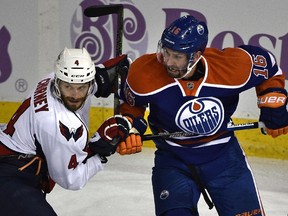 Edmonton Oilers' Teddy Purcell (16) and Washington Capitals' Taylor Chorney (4) jostle for position during NHL action at Rexall Place in Edmonton, October 24, 2015. The Oilers lost 7-4.