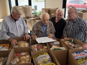 Checking their list of  Edmonton Food Bank recipients are church volunteers, from left, Leo Allemekinders, Sam Talsma, John Jager and Jake Bonnema at Inglewood Christian Reformed Church.