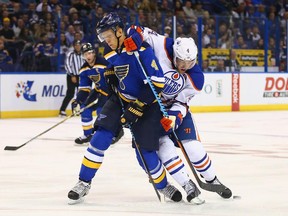 Carl Gunnarsson of the St. Louis Blues and Taylor Hall of the Edmonton Oilers fight for control of the puck at the Scottrade Center on October 8, 2015 in St. Louis, Missouri.