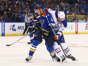 Carl Gunnarsson (4) of the St. Louis Blues and Taylor Hall (4) of the Edmonton Oilers fight for control of the puck at the Scottrade Center on Oct. 8, 2015, in St. Louis, Mo.