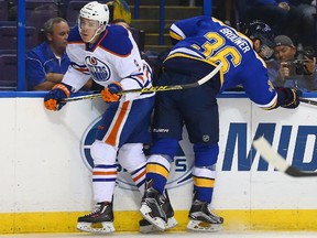 ST. LOUIS, MO - OCTOBER 8:  Troy Brouwer #36 of the St. Louis Blues checks Connor McDavid #97 of the Edmonton Oilers into the boards at the Scottrade Center on October 8, 2015 in St. Louis, Missouri.