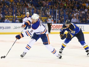 Griffin Reinhart of the Edmonton Oilers shoots the puck against Dmitrij Jaskin of the St. Louis Blues at the Scottrade Center on October 8, 2015 in St. Louis, Missouri. The Blues won 3-1.