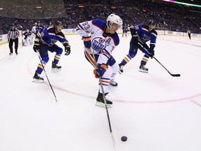 Ryan Nugent-Hopkins of the Edmonton Oilers looks to pass the puck against Jay Bouwmeester, 19, and Jori Lehtera, 12, of the St. Louis Blues at the Scottrade Center on October 8, 2015 in St. Louis, Missouri.