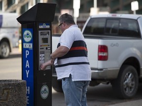 A motorist uses one of the new EPark machines in downtown Edmonton on Oct. 21, 2015. The City of Edmonton is officially launching its EPark system, starting with new machines around city hall. Motorists can pay using credit cards, coins or a smartphone app.