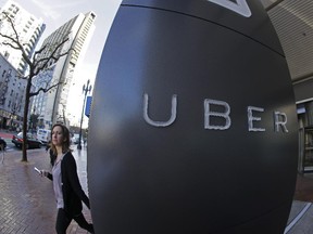 A woman leaves the headquarters of Uber in San Francisco, Calif.
