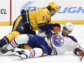 Nashville Predators left wing Gabriel Bourque (57) falls on Edmonton Oilers defenceman Justin Schultz (19) in the second period of an NHL hockey game Saturday, Oct. 10, 2015, in Nashville, Tenn.