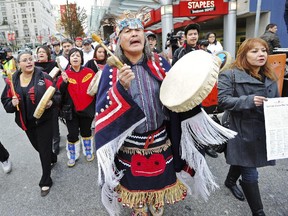 Chief Dolly Abraham, right, from Tatla Lake First Nations, holds a declaration as supporters march along Burrard Street to the offices of Enbridge in Vancouver on Dec. 2, 2010.