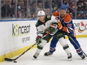 Minnesota Wild's Jordan Schroeder and Edmonton Oilers' Darnell Nurse battle for the puck behind the net in a pre-season hockey game in Saskatoon on Sept. 26, 2015.