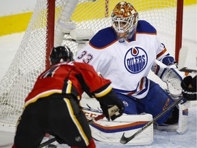 Edmonton Oliers' goaltender Cam Talbot, right, blocks the net on a shot from Calgary Flames' Kris Russell (4) during first period NHL hockey action in Calgary on Saturday, Oct. 17, 2015.