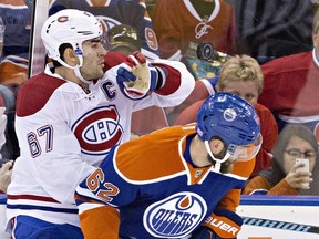 Montreal Canadiens' Max Pacioretty (67) grabs the puck as he battles with Edmonton Oilers' Eric Gryba (62) during second period NHL action in Edmonton, Alta., on Thursday October 29, 2015.