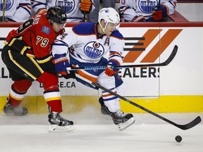 Edmonton Oilers' Taylor Hall gets past Calgary Flames' Michael Ferland during third period NHL hockey action in Calgary on Saturday, Oct. 17, 2015.