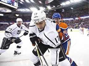 Los Angeles Kings Milan Lucic (17) battles in the corner with Edmonton Oilers Ryan Nugent-Hopkins (93) as Jeff Carter (77) looks for the puck in Edmonton on Oct. 25, 2015.