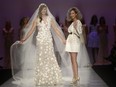 Designer Nikki Wirthensohn walks the runway with a model in the Narces show, part of Fashion Week in Toronto on Wednesday, Oct. 21.