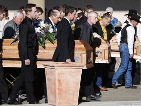 Pall bearers carry the three coffins of Catie Bott, 13, and her twin 11-year-old siblings, Jana and Dara Bott in Red Deer, Alta., Friday, Oct. 23, 2015. The girls suffocated when they became buried in the back of a truck filled with canola on a farm near Withrow.