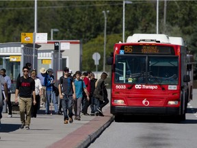 Passengers get on an OC Transpo rapid transit bus in Ottawa in September.