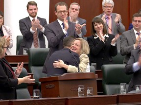 Finance Minister Joe Ceci receives a hug from Premier Rachel Notley after reading the NDP's 2015 Alberta budget at the Alberta legislature in Edmonton on Oct. 27, 2015.