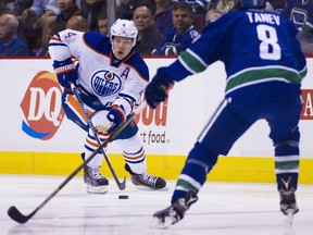 Edmonton Oilers Taylor Hall (4) skates with the puck against the Vancouver Canucks during the first period of an NHL hockey game in Vancouver, B.C., on Sunday, October 18, 2015.