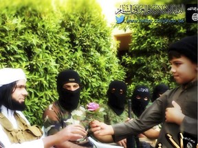 This Screen grab from an Islamic State group affiliated Twitter account, taken last fall, purports to show senior military commander Abu Wahib handing a flower to a child while visiting southern Iraq. The group's increasingly sophisticated media campaign has rallied disenfranchised youth.