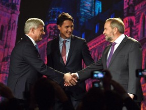 Conservative Leader Stephen Harper, left, and NDP Leader Tom Mulcair shake hands as Liberal Leader Justin Trudeau looks on during their introduction prior to the Globe and Mail hosted leaders' debate in Calgary on September 17, 2015.