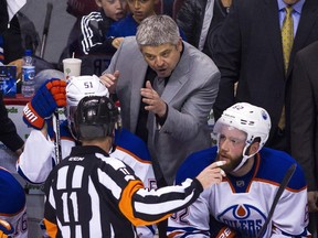 Edmonton Oilers head coach Todd McLellan speaks with referee Kelly Sutherland (11) during a stoppage in play against the Vancouver Canucks during the second period of an NHL hockey game in Vancouver, B.C., on Sunday October 18, 2015.