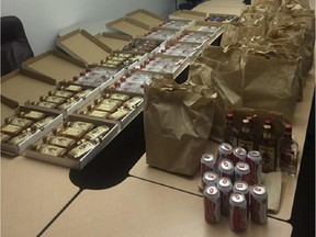 A photo supplied by Edmonton Police Service shows various bottles of alcohol in pizza boxes and paper bags recovered from a north-side pizza restaurant.