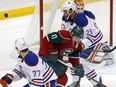 A shot goes high and wide past Minnesota Wild's Zach Parise (11) as Edmonton Oilers' Darnell Nurse (25) defends in the first period of an NHL hockey game, Tuesday, Oct. 27, 2015, in St. Paul, Minn.